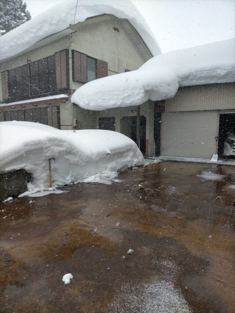 所有する戸建てに雪が降り、雪が屋根を押しつぶそうとしている写真